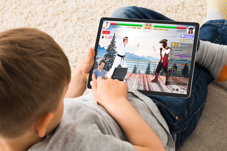 Ein Junge spielt an einem Tablet ein Spiel. Eine Studie des Deutschen Kinderhilfswerks untersucht, wie Kinder zum Beispiel bei Online-Spielen mit unerwünschten Kontaktaufnahmen und weiteren Interaktionsrisiken im Netz umgehen. 