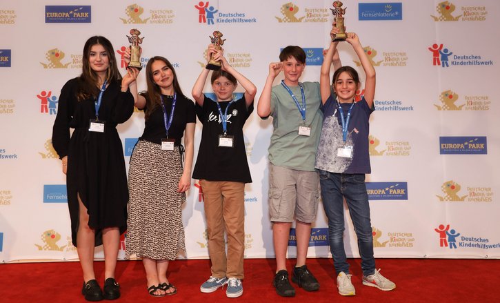 Die Gewinnerinnen und Gewinner des Deutschen Kinder- und Jugendpreises stehen mit ihren Auszeichnungen auf dem Roten Teppich. 