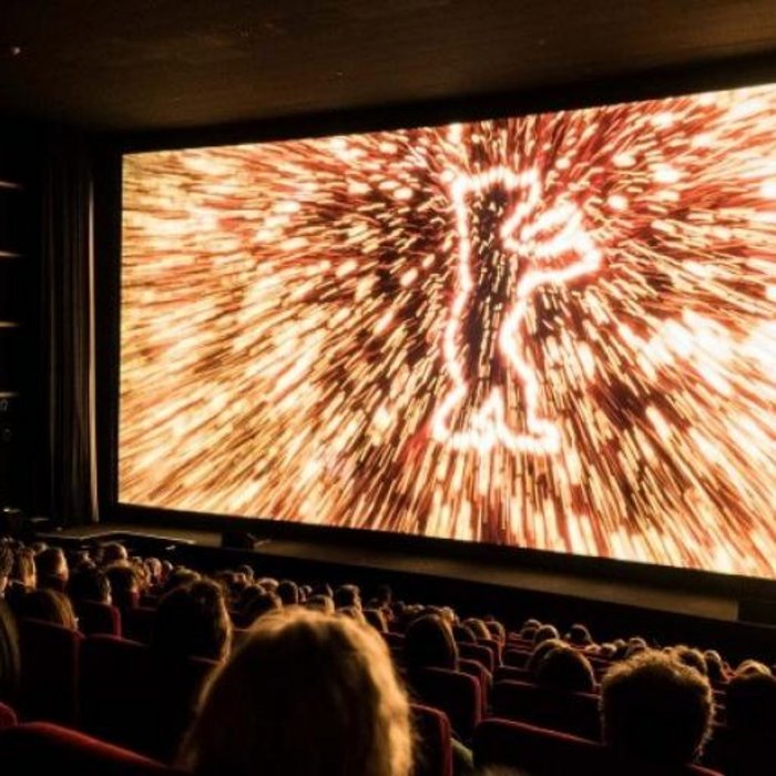Kinosaal während der Berlinale 2023 mit der Eröffnungssequenz und dem Berlinale-Bären auf der Leinwand.