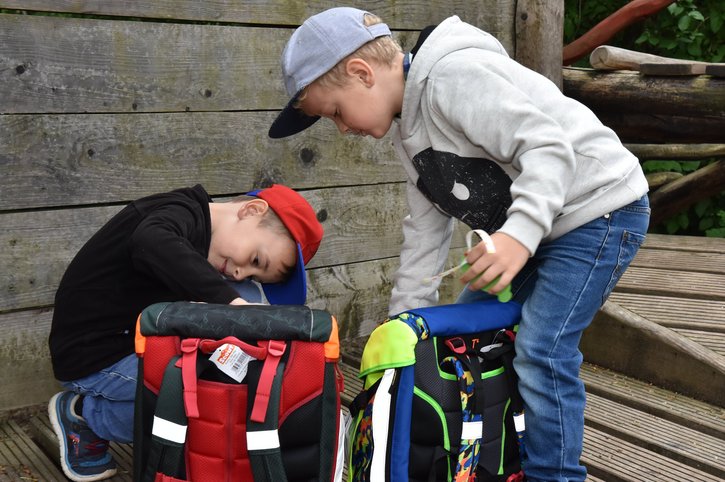 Zwei Jungen packen bei der Schulranzen-Aktion des Deutschen Kinderhilfswerks Schulranzen aus. 