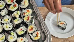 Das Bild zeigt einen Tisch, auf dem eine Sushiplatte steht. 