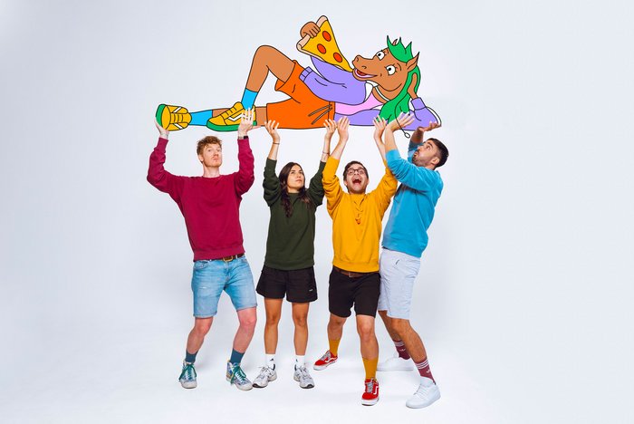 Die vier Mitglieder der Band Honigkuchenpferde halten ihr Maskottchen Pferdi in die Höhe, ein animiertes Pferd