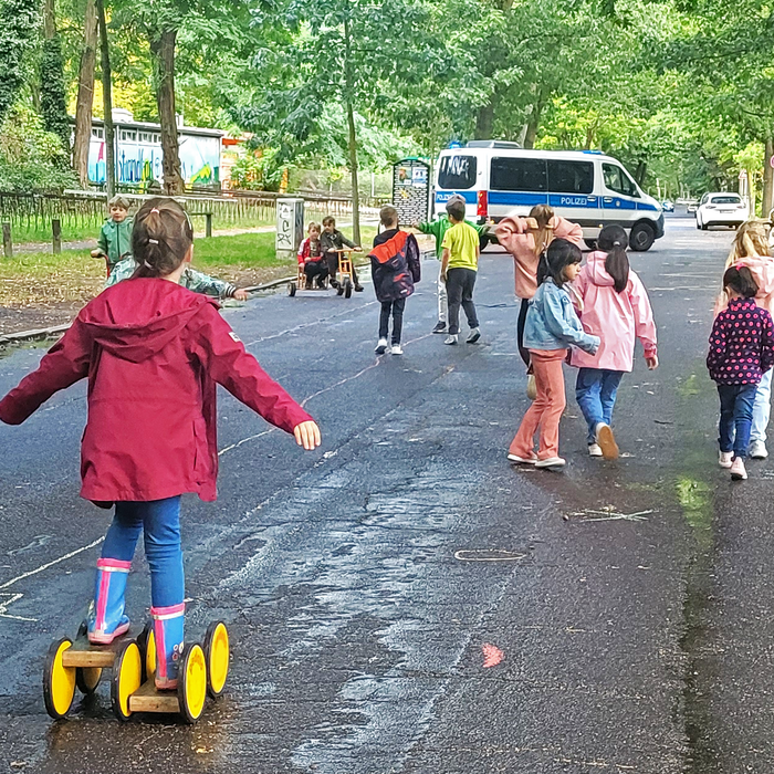 Kinder spielen auf einem von der Polizei abgesperrten Straßenabschnitt.