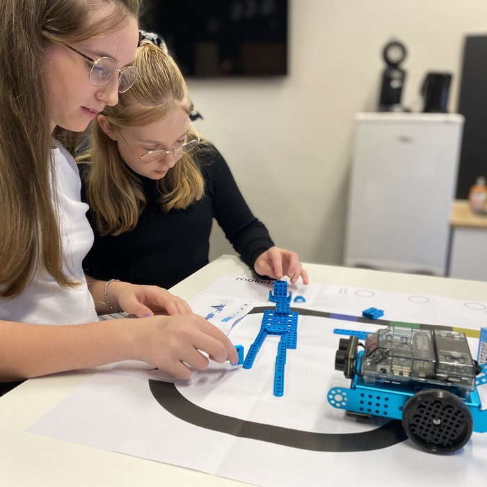 Zwei Schülerinnen bauen ein Auto aus verschiedenen Steinen und Platten zusammen